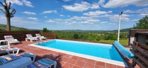 a swimming pool with chairs and a view at Vila Lisina in Seliste Dreznicko