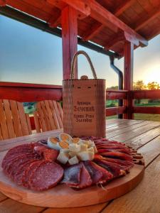 ein Teller mit Fleisch und Käse auf einem Holztisch in der Unterkunft Brvnara Zečević in Zlatibor
