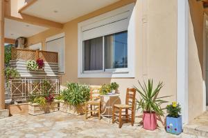 a patio with chairs and plants in front of a building at Paralia Vergas Apartments Studio in Verga Kalamata