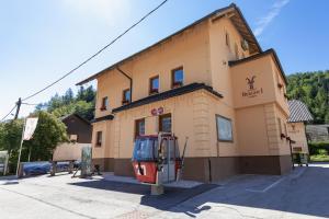 un edificio con una señal delante de él en Berghi Hotel and Apartments en Kranjska Gora