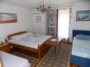 a bedroom with a bed and a table and a window at Apartments Miro Kornić in Kornić