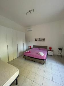 マリーナ・ディ・マンカヴェルサにあるCasa Cleaのベッドルーム1室(ピンクベッド1台付)