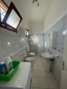 マリーナ・ディ・マンカヴェルサにあるCasa Cleaの白いバスルーム(トイレ2つ、シンク付)