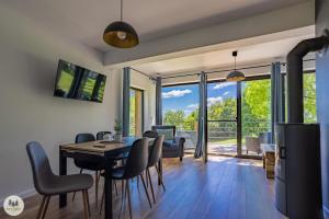 a dining room and living room with a table and chairs at Przystanek Gorce in Nowy Targ