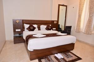 een slaapkamer met 2 bedden en een spiegel bij Hotel Radiance Courtyard in Varanasi