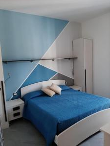 サン・ヴィート・ロ・カーポにあるB&B "Perla del Sud"のベッドルーム1室(青と白のベッド1台、枕2つ付)