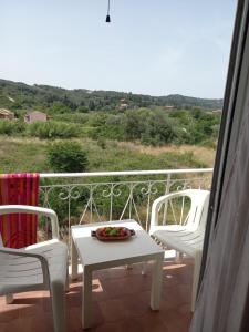 balcón con mesa, 2 sillas y vistas en Natassa House 2 en Agios Georgios Pagon