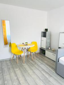 una sala da pranzo con tavolo e sedie gialle di Miha modern and central apartament a Arad