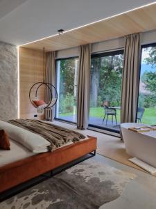a bedroom with a large bed and large windows at Garden Retreat Junior in Bran