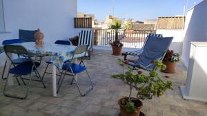 un patio con tavolo e sedie sul balcone. di Sogno d'estate a Mazara del Vallo