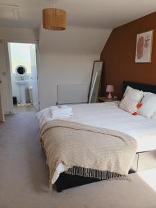 a bedroom with a large bed with a blanket on it at Queensize private room - en suite and free parking in Silverdale