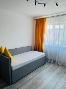 Posto letto in camera con tenda arancione. di Miha modern and central apartament a Arad