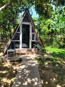 a small house with a porch in a garden at Tam Tinh Vien Homestay in Hue
