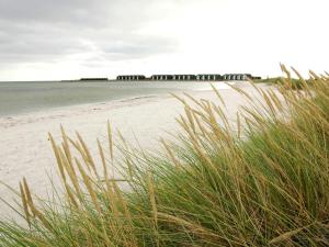 Øster Hurupにある6 person holiday home in Hadsundの芝生と海と桟橋のあるビーチ