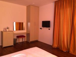 薩蘭達的住宿－Nemesis Hotel，一间卧室配有一张床、一张书桌和一台电视