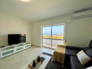 クアルテイラにあるQuarteira Panoramic View by Homingのソファと薄型テレビのあるリビングルーム