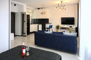 a living room with a blue couch and a kitchen at Glamour Apartment - w samym sercu miasta, nieopodal rynku in Katowice