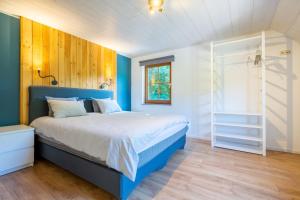een slaapkamer met een blauw en wit bed en een raam bij Bills Lodge, le plaisir de la rivière à 2 minutes du centre! in La-Roche-en-Ardenne