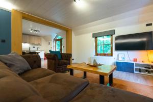 a living room with a couch and a table at Bills Lodge, le plaisir de la rivière à 2 minutes du centre! in La Roche-en-Ardenne