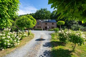 een grindweg die leidt naar een oud stenen huis bij Bills Lodge, le plaisir de la rivière à 2 minutes du centre! in La-Roche-en-Ardenne
