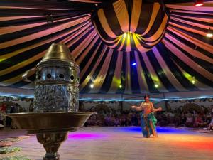 a man standing in front of a performance in a tent at SOULOTEL EMERALD Resort & Spa in Marsa Alam City +83 photos