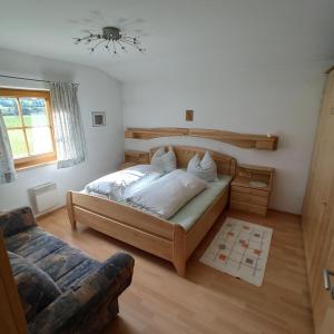 sypialnia z dużym łóżkiem i kanapą w obiekcie Ferienwohnung Zillertaler Alpenblick w mieście Zell am Ziller