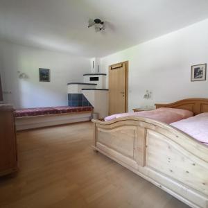 sypialnia z drewnianym łóżkiem w pokoju w obiekcie Ferienwohnung Zillertaler Alpenblick w mieście Zell am Ziller