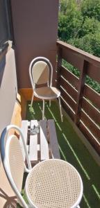 d'un balcon avec une chaise, une table et des chaises. dans l'établissement STUDIO DE LA BICHETTE, à Besse-et-Saint-Anastaise