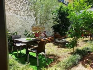 a table and chairs in a garden with trees at Vila Koltrina in Shkodër