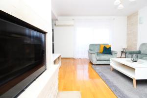 sala de estar con TV de pantalla plana grande en Apartments Lotta, en Zadar