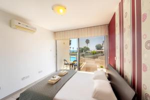 a bedroom with a bed with a view of the ocean at Fig Tree bay Apartment 103 in Protaras