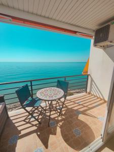 balcón con mesa, sillas y vistas al océano en Santa-Clara-Blue Horizon. Front Line Apartment, en Torremolinos