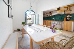 - une cuisine avec une table et des chaises blanches dans l'établissement POM Alaçatı Boutique Otel, à Çeşme