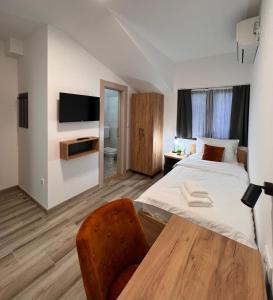 a bedroom with a bed and a table and a tv at Prenociste kod Brana in Čačak