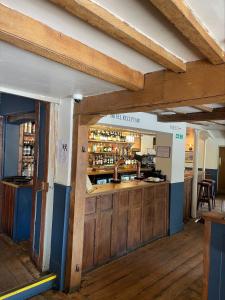 un bar en un pub con suelo de madera y vigas de madera en Miller of Mansfield en Goring