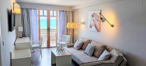 ein Wohnzimmer mit einem Sofa und Meerblick in der Unterkunft Ammos Suites in Rethymno