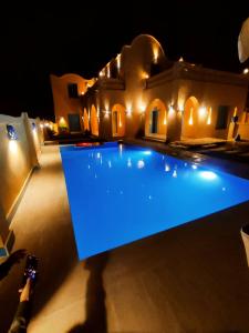 una piscina frente a una casa por la noche en فيلا شمس تونس, en Tunis