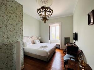 a bedroom with a bed and a chandelier at Casa do Principe in Lisbon