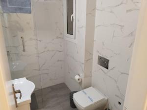 Baño blanco con aseo y lavamanos en Zeus Apartment en Atenas