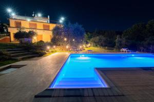 ein Schwimmbad vor einem Gebäude in der Nacht in der Unterkunft Poggio delle Rose Tuscany Relais in Chianciano Terme