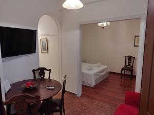 sala de estar con mesa y habitación con cama en Zeus Apartment en Athens
