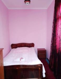 a bedroom with a bed with white sheets and red curtains at Guest House Carpediem in Becho