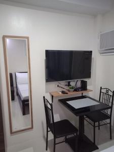 a room with a table and a mirror and a television at Cozy235 studio at The Persimmon in Cebu City