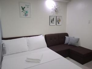 un letto e un divano in una camera di Cozy235 studio at The Persimmon a Cebu City