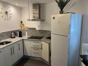 a kitchen with a white refrigerator and a sink at Villa El Loto Blanco beautiful apartment for rent. in Benissa