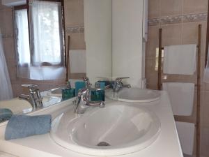 a bathroom with two sinks and a mirror at La Guest House BYLAVILLA25 calme et détente in Noaillan +8 photos