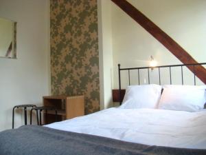 sypialnia z białym łóżkiem z drewnianą ramą w obiekcie Hostel BAZA 15 we Wrocławiu