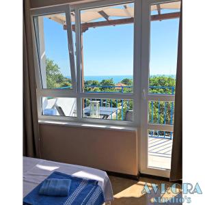 a room with a window with a view of a balcony at Avrora Studio's in Byala