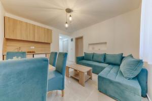 a living room with a blue couch and a table at OLIVE GARDEN APARTMENT in Bar