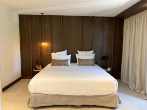 - une chambre avec un grand lit blanc et des murs en bois dans l'établissement Hôtel Spa & Restaurant - Son de Mar, à Porto-Vecchio